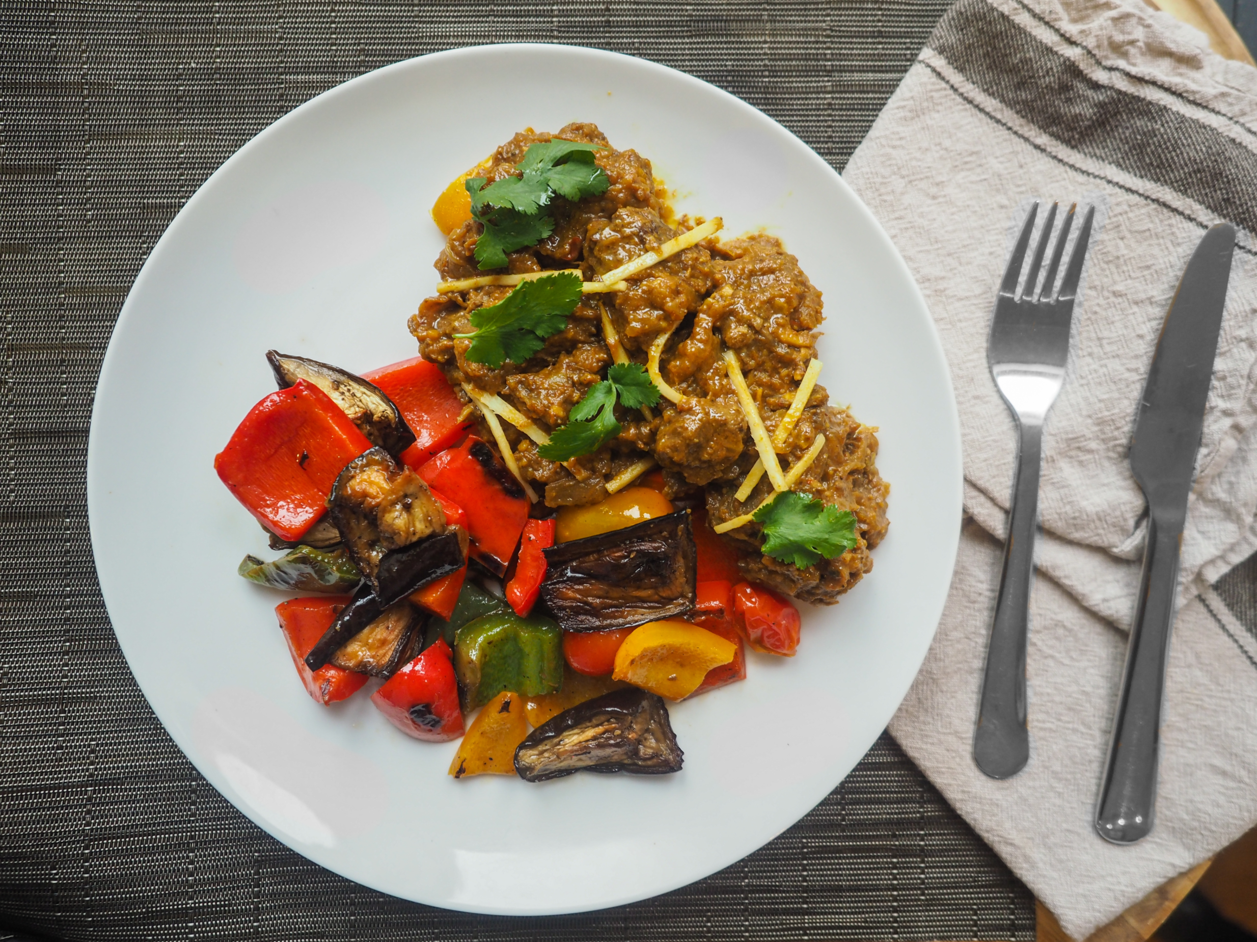 overhead-closeup-shot-middle-eastern-cooked-food-white-plate-with-fork-kitchen-knife